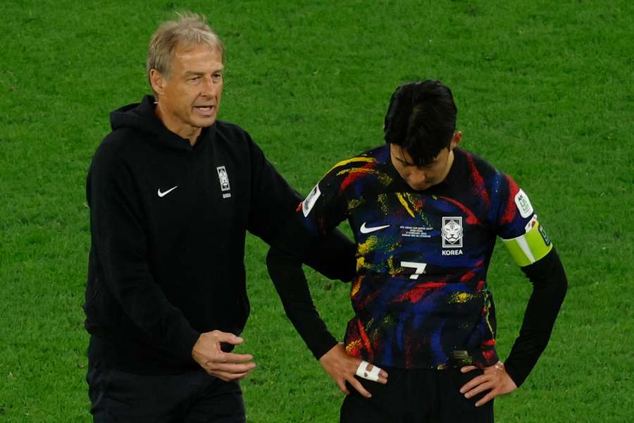 O treinador alemão da Coreia do Sul, Jurgen Klinsmann, fala com Son Heung-min depois de perder com a Jordânia