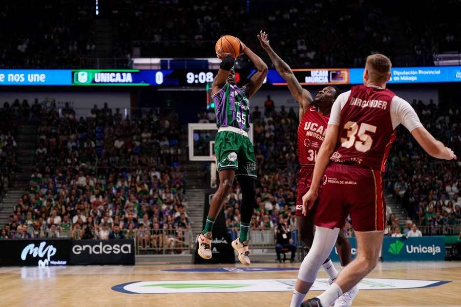 Perry intenta un tiro en suspensión ante Ennis