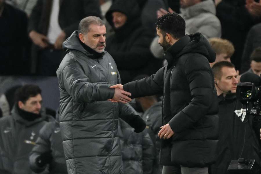 Tottenham Hotspur's Greek-Australian Head Coach Ange Postecoglou (L) shakes hands with Manchester United's Portuguese head coach Ruben Amorim (R) 