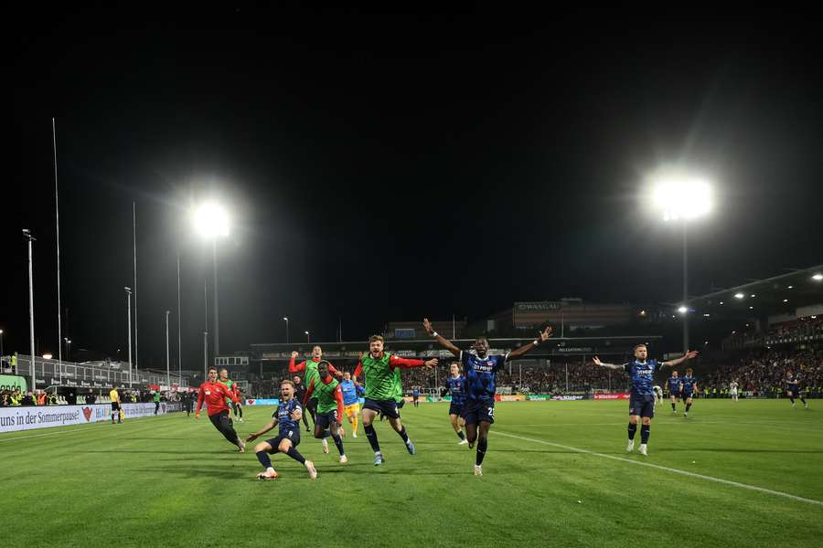 The players of Heidenheim celebrate at full-time following the team's victory in the Bundesliga playoffs