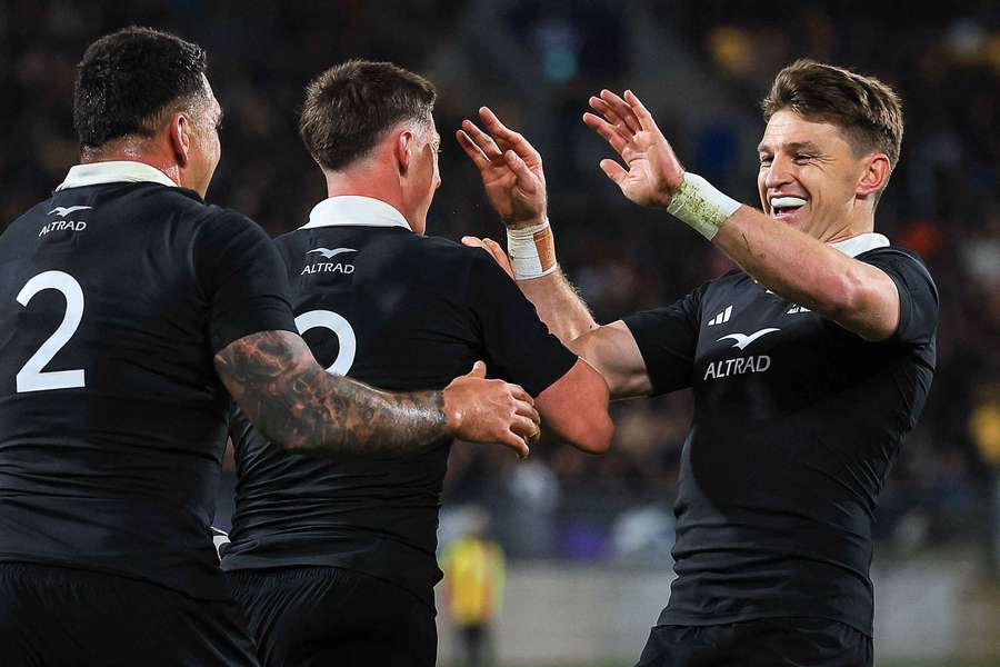 New Zealand's Cam Roigard, centre, celebrates his first try with Beauden Barrett