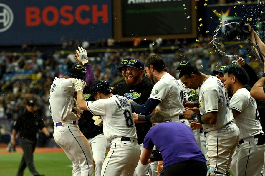 Franco celebrates at home plate with his teammates after hitting a walk off home run in the ninth inning against the Cleveland Guardians