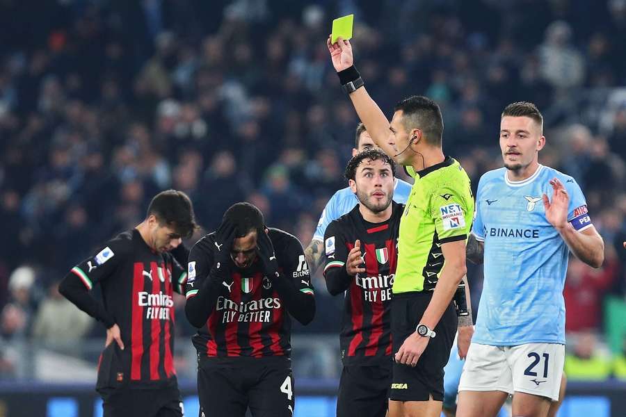 Scheidsrechter Marco Di Bello toont de gele kaart aan  Ismael Bennacer van AC Milan