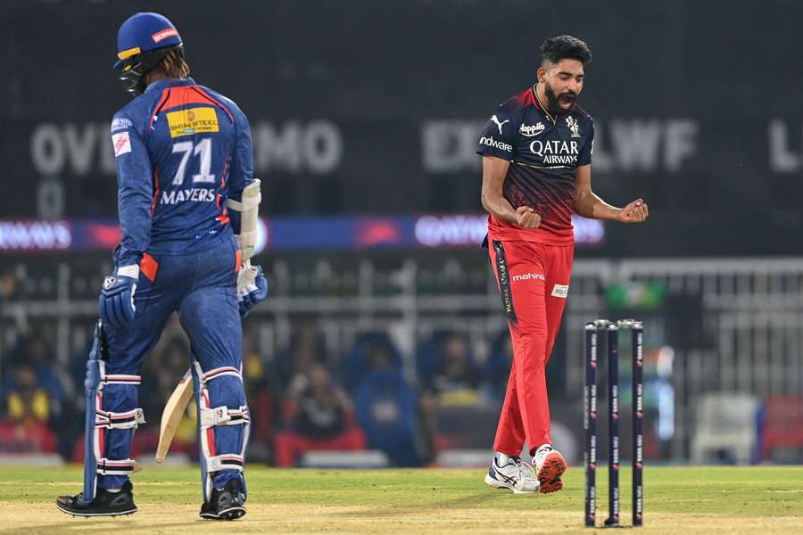 Royal Challengers Bangalore's Mohammed Siraj (R) celebrates after taking the wicket of Lucknow Super Giants' Kyle Mayers (L)