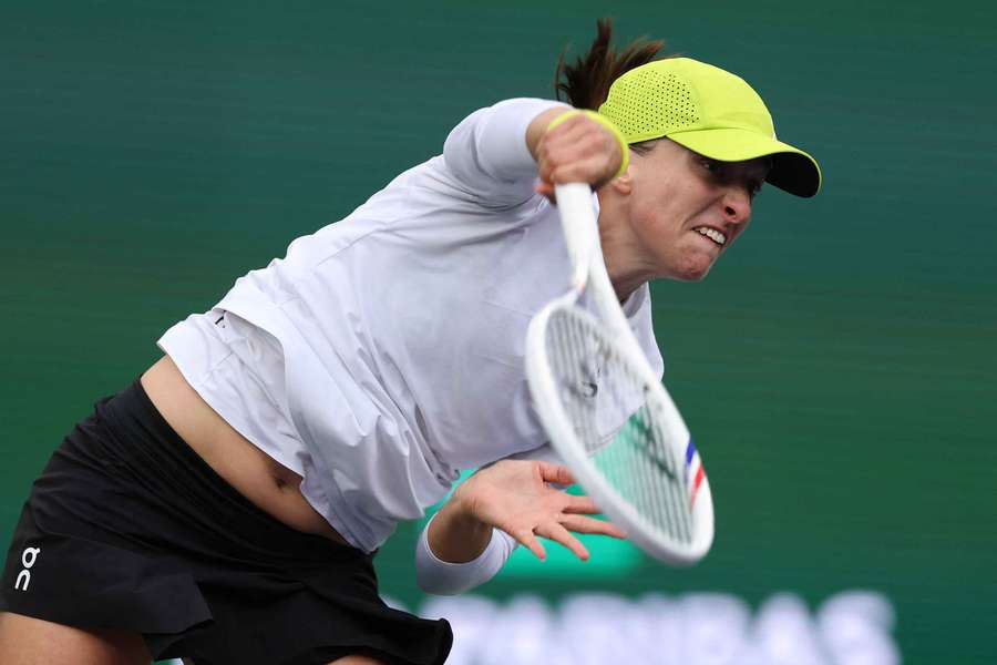 Iga Swiatek serves against Qinwen Zheng at Indian Wells