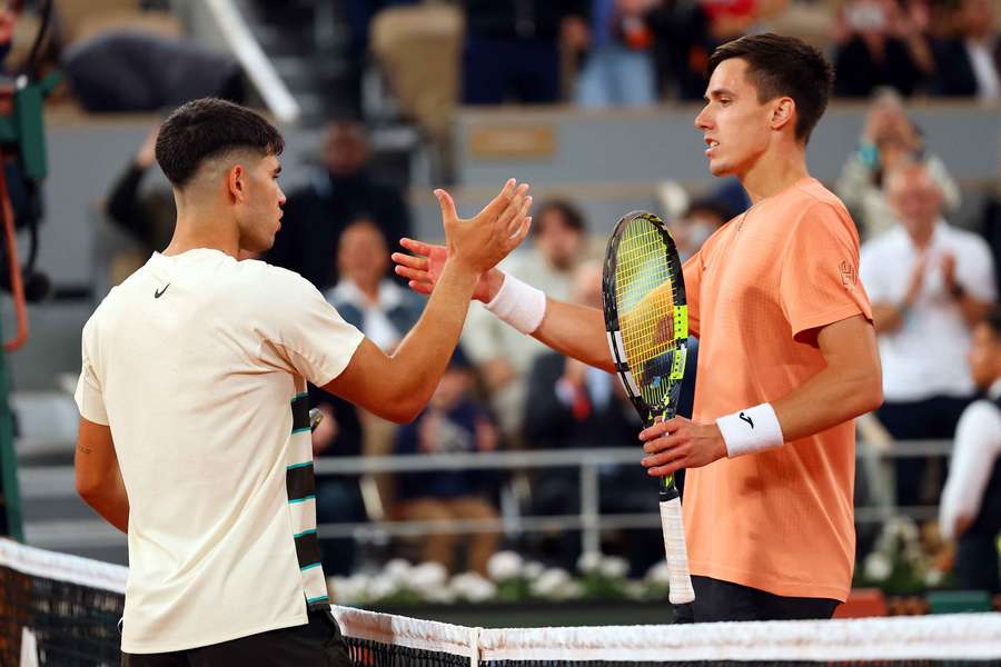 Carlos Alcaraz shakes hands with Fabian Marozsan after winning his second-round match at the French Open