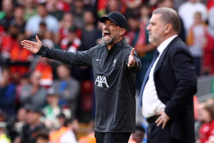 Tottenham Hotspur's Greek-Australian Head Coach Ange Postecoglou (R) and Liverpool's German manager Jurgen Klopp react