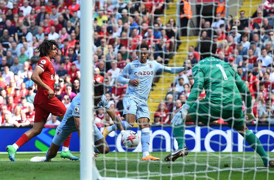 Aston Villa's English midfielder Jacob Ramsey (C) scores the opening goal past Liverpool's Brazilian goalkeeper Alisson Becker