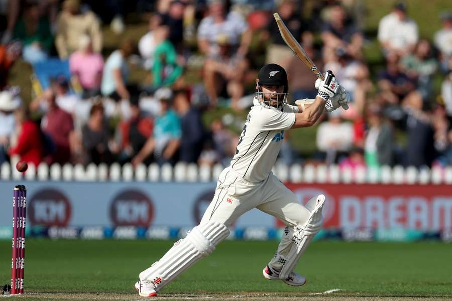 New Zealand's Kane Williamson (C) plays a shot