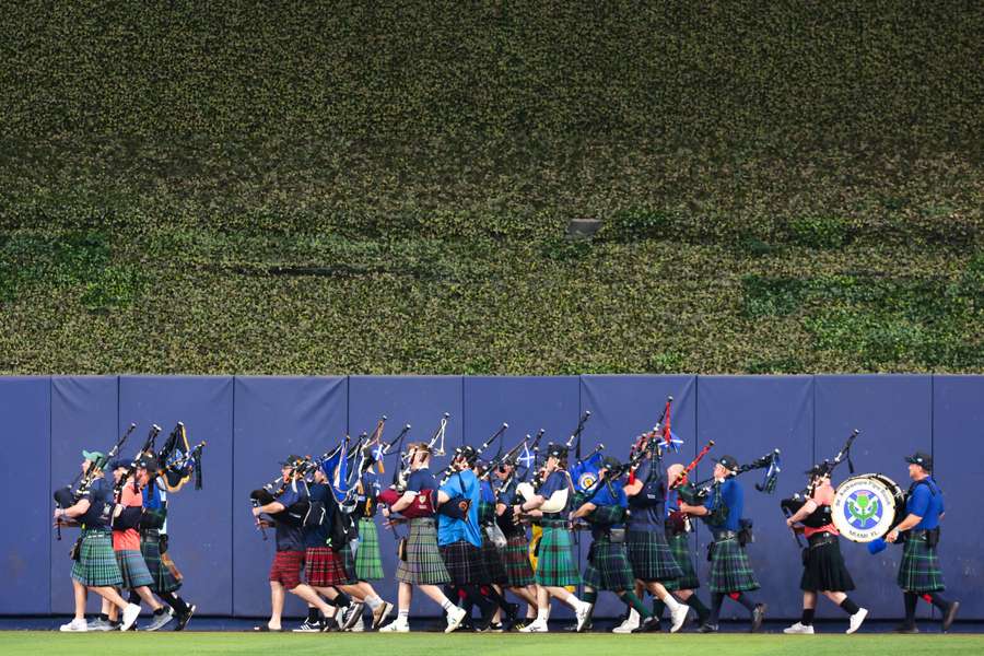 Scotland football fans play bagpipes while walking on the warning track before the game between the Texas Rangers and the Miami Marlins. Scotland football fans play bagpipes while walking on the warning track before the game between the Texas Rangers and the Miami Marlins.