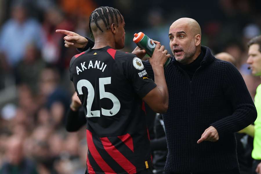 Manchester City's Spanish manager Pep Guardiola (R) speaks with Manchester City's Swiss defender Manuel Akanji during a break in play