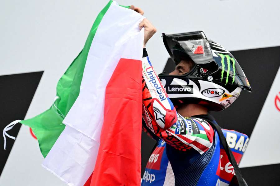 Francesco Bagnaia feiert seinen Sieg mit der italienischen Flagge.