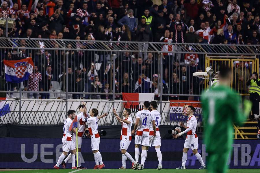 Croatia's forward #11 Ante Budimir (2nd L) celebrates with Croatia's midfielder #10 Luka Modric (C) after scoring the opening goal 