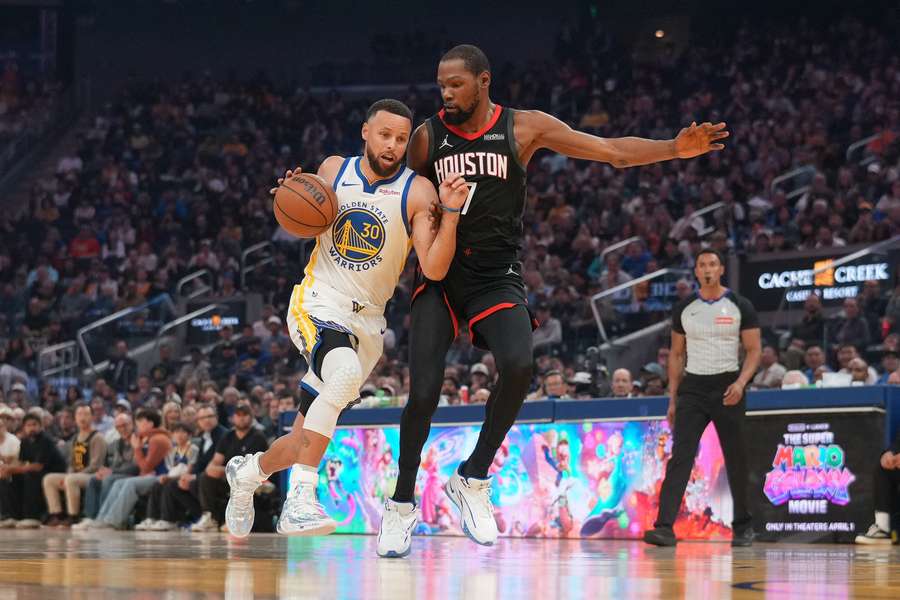 Golden State Warriors guard Stephen Curry dribbles the ball next to Houston Rockets forward Kevin Durant