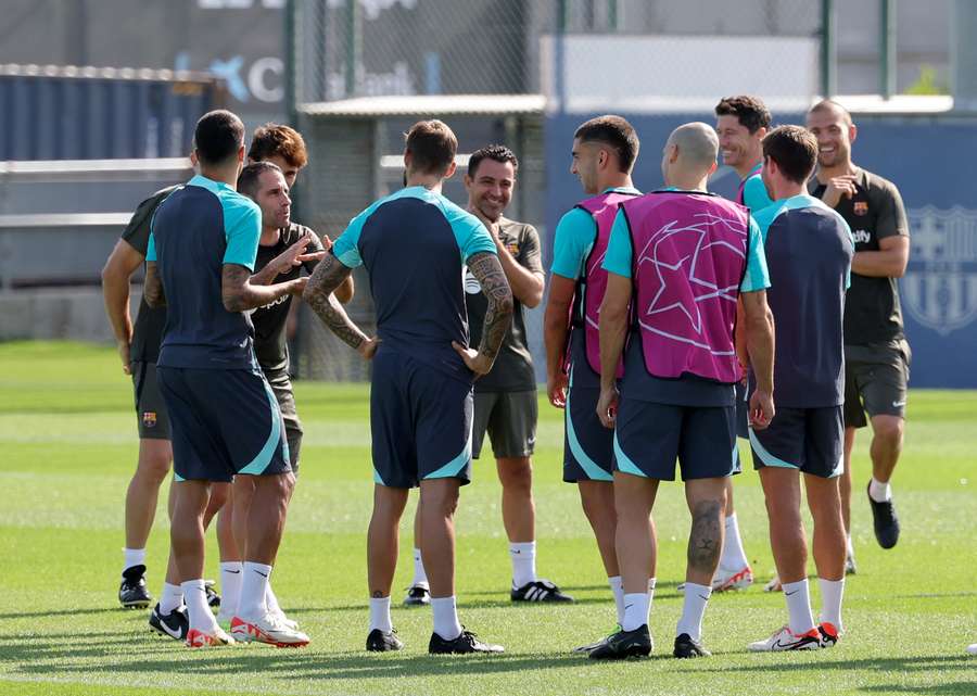 Barcelona's Spanish coach Xavi, centre, talks with his players during a training session ahead of their game against Royal Antwerp