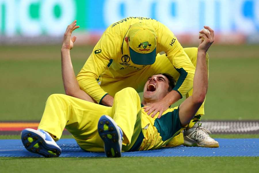 Australia's Pat Cummins celebrates with Manus Labuschagne after taking the catch to dismiss South Africa's Quinton de Kock