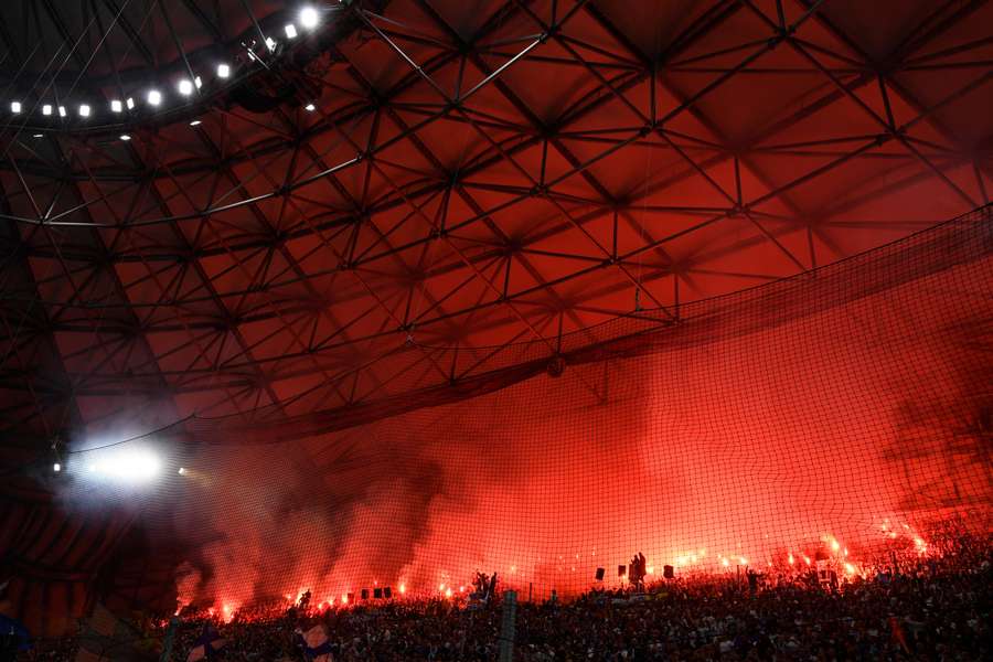 Fans lighting flares during a Ligue 1 match between Marseille and Lyon at Stade Velodrome