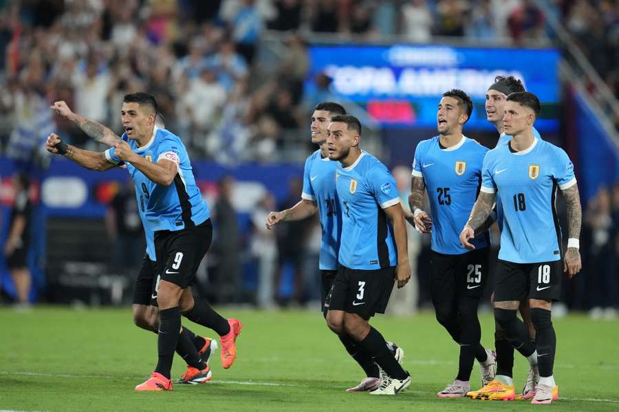 Uruguay's players watch the penalties