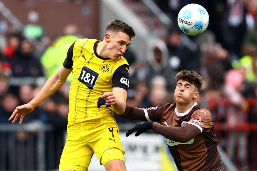 Borussia Dortmund's Nico Schlotterbeck (left) in action with FC St. Pauli's Noah Weisshaupt