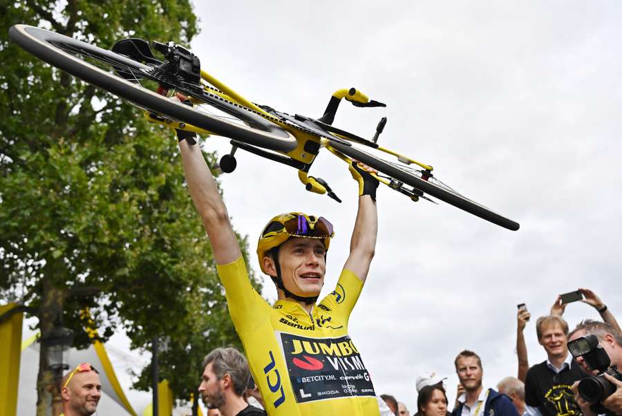 Jonas Vingegaard lifts his bike as he celebrates winning the Tour de France
