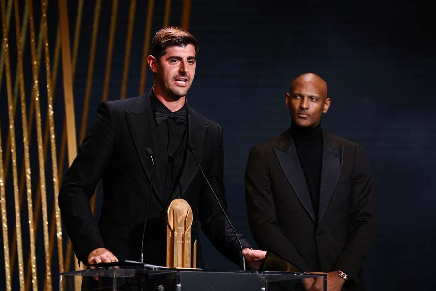 Real Madrid's Belgian goalkeeper Thibaut Courtois receives the Yashin Trophy for best goalkeeper from Dortmund's Ivorian forward Sebastien Haller