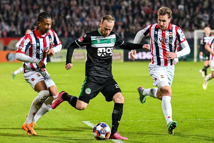 Rob Nizet en Matthias Verreth van Willem II proberen FC Groningen-aanvaller Romano Postema af te stoppen