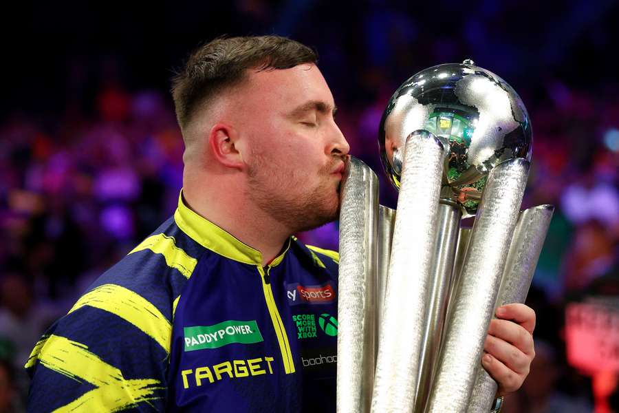 Luke Littler kisses the Sid Waddell trophy after defeating Gian van Veen in the PDC World Darts Championship final