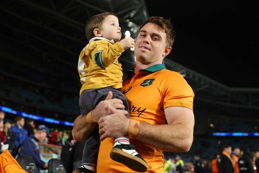 Andrew Kellaway celebrates the Wallabies' third Test victory against the British & Irish Lions in Sydney with his son.