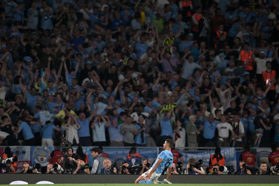 Rodri celebrates with City fans in the background