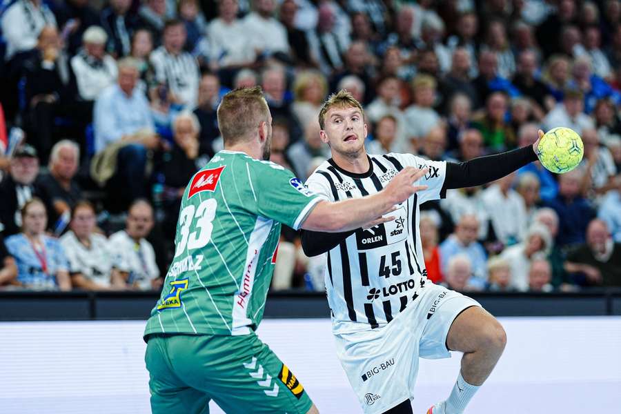 Michael Schulz from GWD Minden tries to stop Madsen in a game in the German Bundesliga