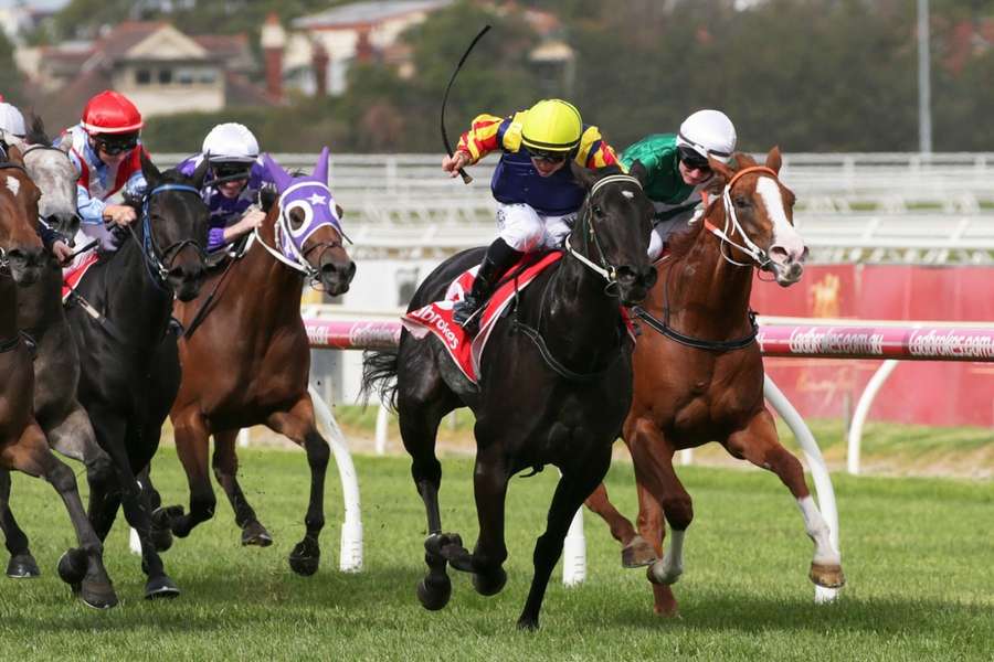 Dean Holland (centre) rides at Caulfield Racecourse in 2019