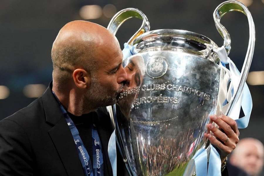 Pep Guardiola kisses the Champions League trophy after guiding Manchester City to a historic treble