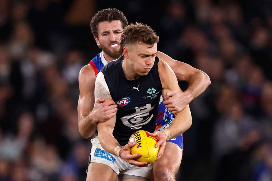 Marcus Bontempelli lays a tackle on Patrick Cripps in 2024.