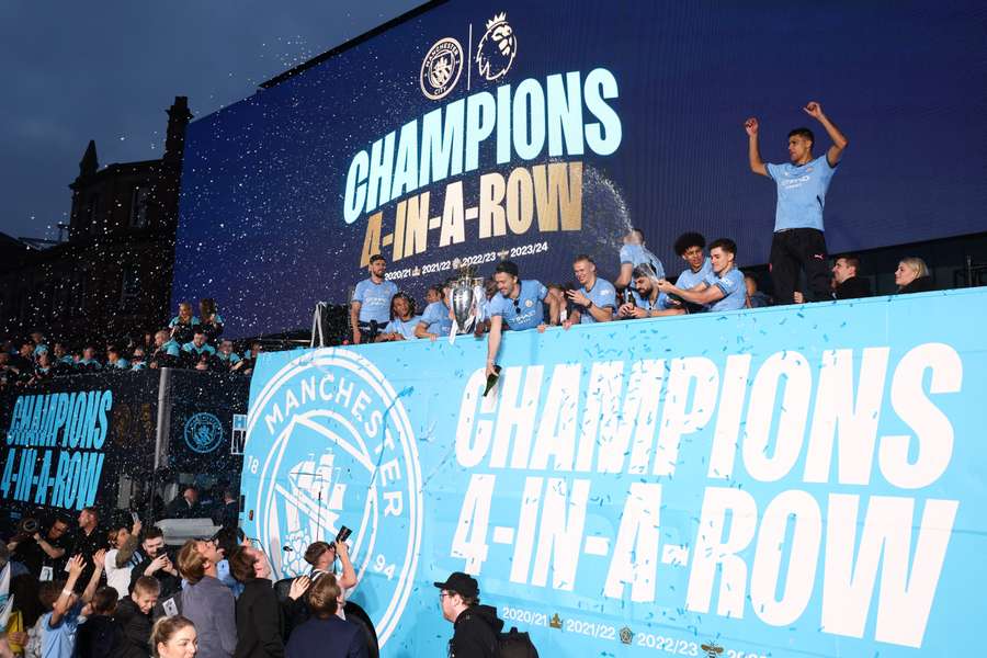 Manchester City's players celebrate during an open-top bus victory parade for Manchester City's Premier League title win