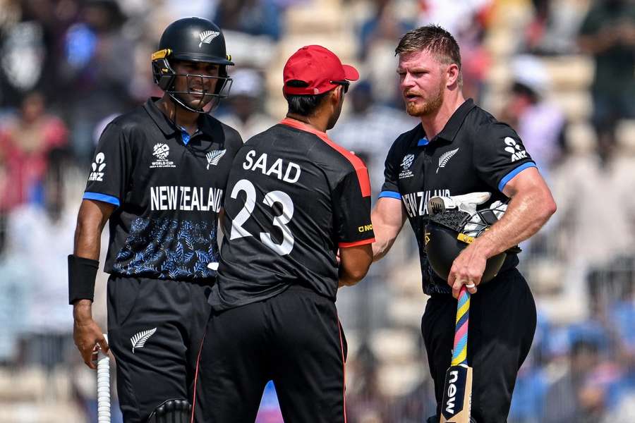 Canada's Saad Bin Zafar (C) congratulates New Zealand's Glenn Phillips (R) and Rachin Ravindra for their team's win 