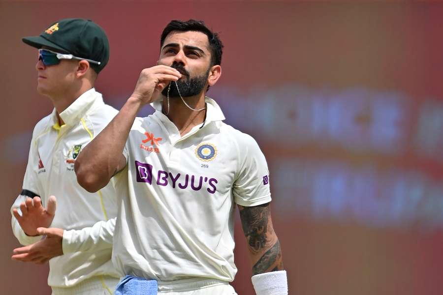 India's Virat Kohli (R) celebrates after scoring a century