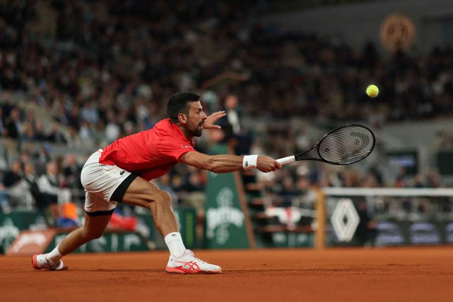 Djoković wyciąga się do forhendu przeciwko Amerykaninowi Mackenzie McDonald podczas meczu French Open 2025