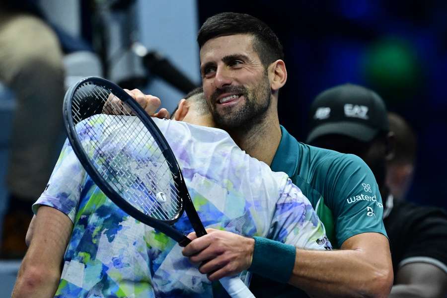 Novak Djokovic hugs Hubert Hurkacz after winning the first round-robin match at the ATP Finals in Turin