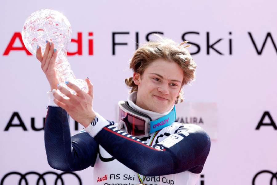 Lucas Braathen celebrates with the globe trophy on the podium after becoming the world champion in 2023