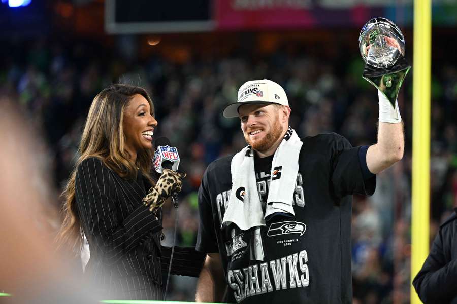 Seattle Seahawks quarterback Sam Darnold hoisting the trophy after winning the Super Bowl.