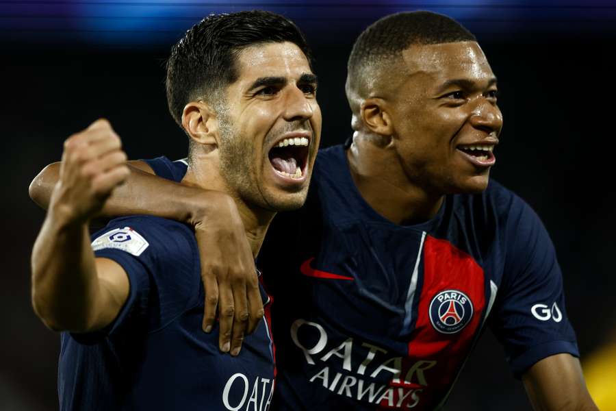 Marco Asensio en Kylian Mbappé vieren een goal van PSG tegen Lens