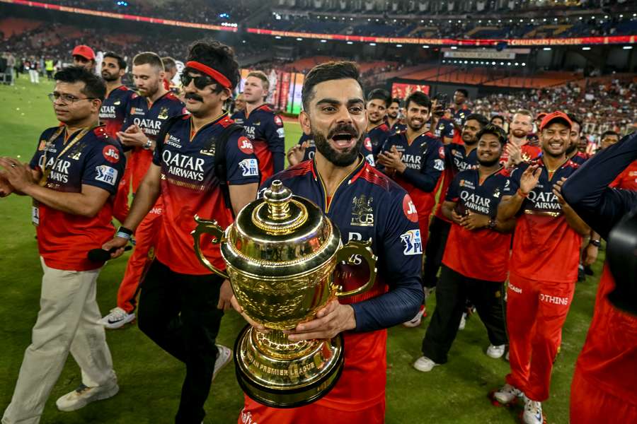Royal Challengers Bengaluru's Virat Kohli takes a victory lap around the field with his teammates