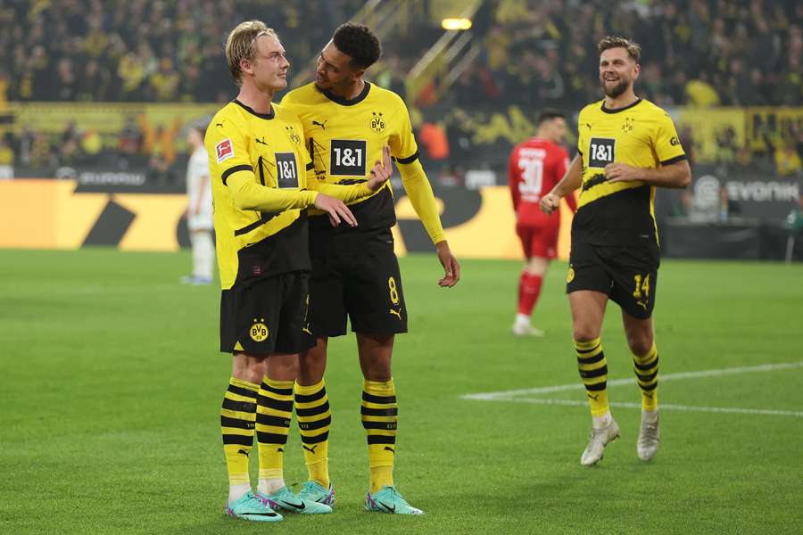 Julian Brandt (l.) lässt sich von Teamkollege Felix Nmecha (M.) zu seinem Siegtreffer beglückwünschen.