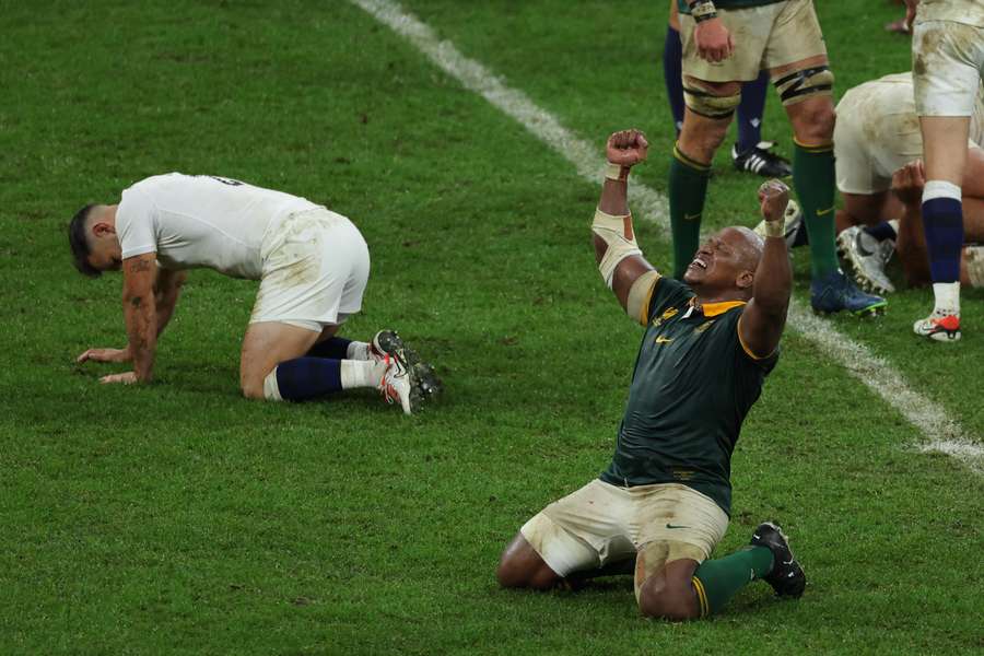 Bongi Mbonambi (R) raises his arms and sinks to his knees as he celebrates South Africa's victory