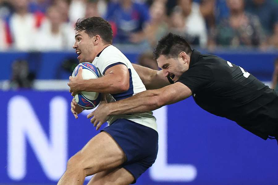 O flanqueador neozelandês Luke Jacobson (à dir.) enfrenta o scrum-half e capitão francês Antoine Dupont O flanqueador neozelandês Luke Jacobson (à dir.) enfrenta o scrum-half e capitão francês Antoine Dupont
