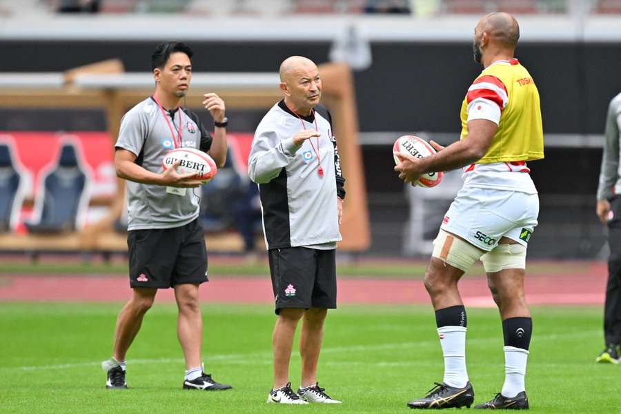 Eddie Jones runs Michael Leitch through a training drill on Friday.
