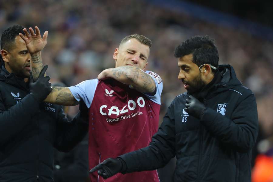 Aston Villa's French defender Lucas Digne is helped off the pitch