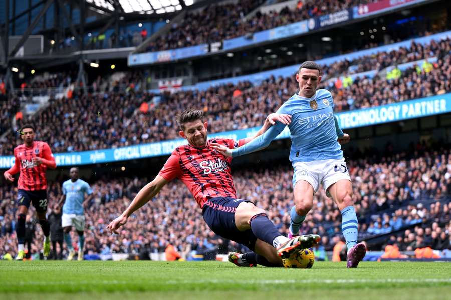 Křídelník City Phil Foden v souboji s Jamesem Tarkowskim z Evertonu.