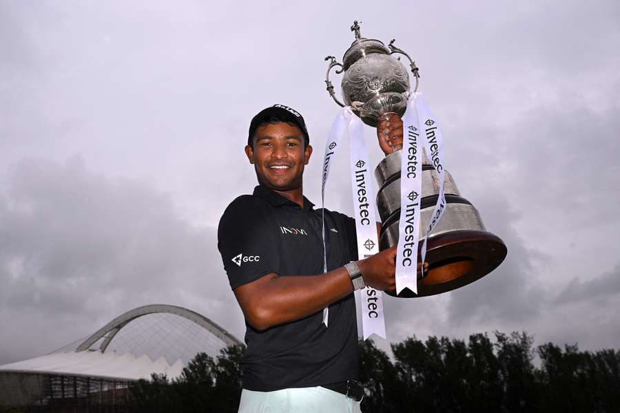Dylan Naidoo of South Africa celebrates victory with the trophy following a playoff against Laurie Canter