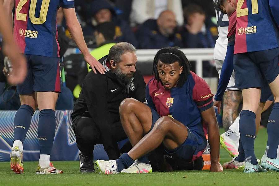Jules Kounde was treated by medical staff before he was replaced in the 42nd minute